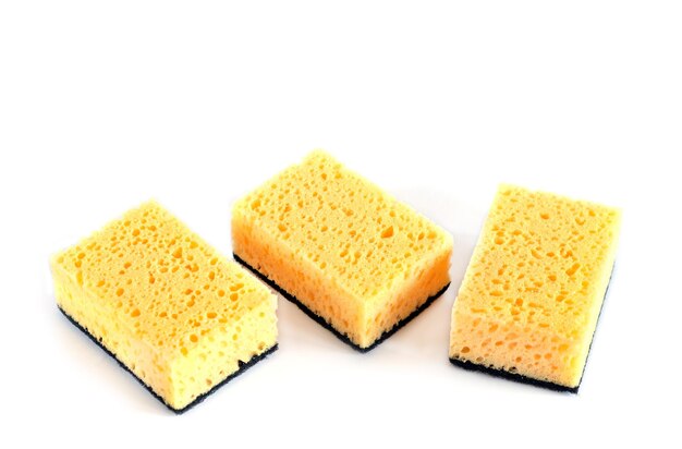 Three yellow sponges for washing dishes and other domestic needs isolated on white background