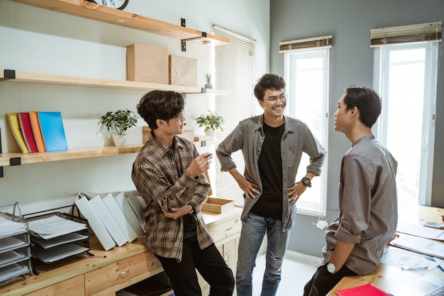 Three young asian businessman chatting about their product
