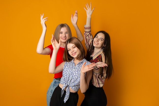 three young beautiful women with their hands up