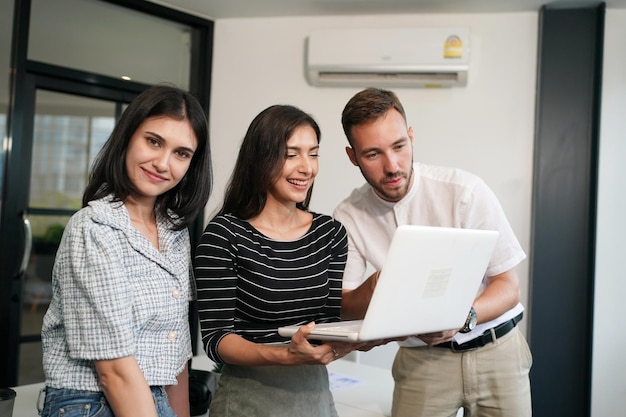 Three young business professionals standing together and discussing over business report