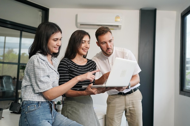 Three young business professionals standing together and discussing over business report