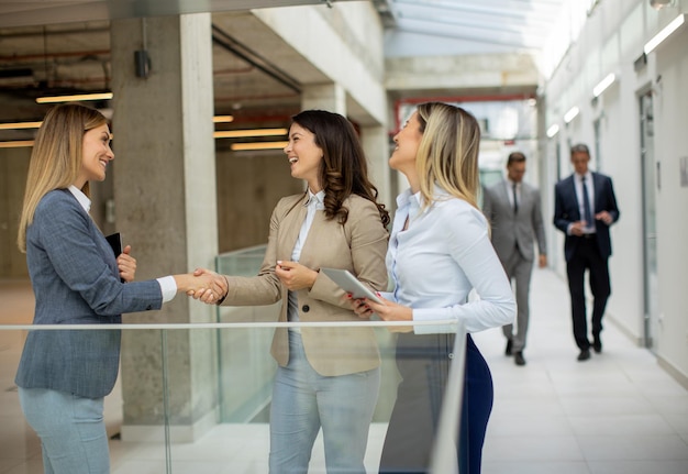 Three young business women having a discussion in the office hallway