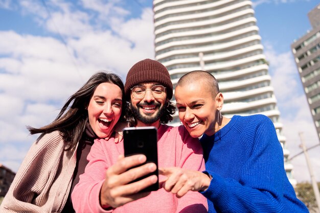 Three young friends enjoying together with a phone