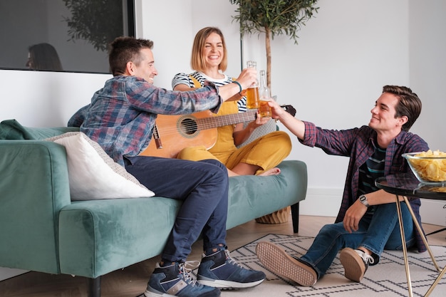 Foto tre giovani amici che brindano con la birra a una festa a casa concept lifestyle friendship together