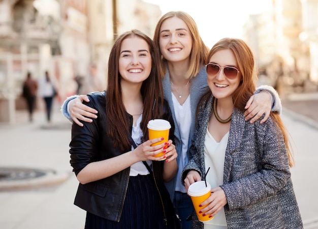 Tre giovani amici con tazze di caffè