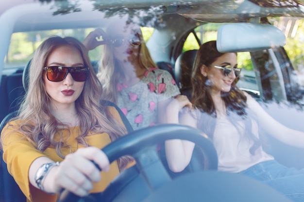 Photo three young girlfriends traveling in a car