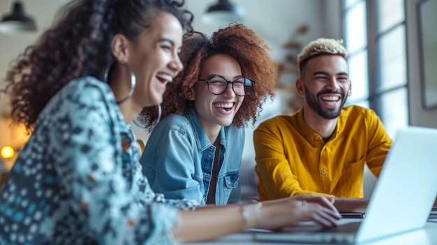 Photo three young people laughing while looking at a laptop