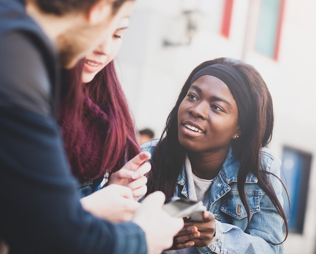 Three young people using mobile phone.