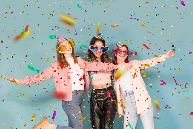 Three  young teen girls having party with confetti 