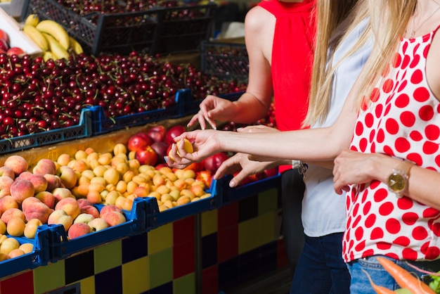 Три молодые женщины на продуктовом рынке.