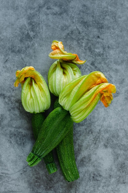 Tre fiori di zucca su uno sfondo di pietra