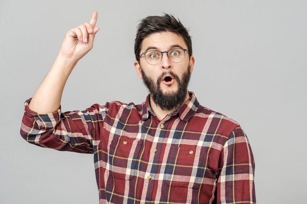 Thrilled excited guy in glasses isolated over gray