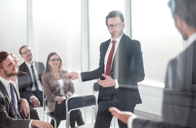 Through the glassthe Manager makes a report at a business meeting