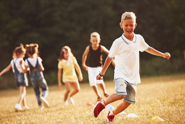 Through obstacles. Kids running in the field at sunny day. Conception of healthy lifestyle.