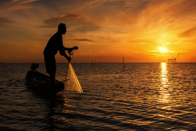 Throwing fishing net during sunrise, Thailand 