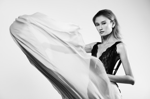 Throwing Flow transparent Fabric in the Air by Beautiful Asian Woman in Black Body Suit lace leotard, Girl dance wave cloth moving blur motion sexy shape, studio lighting off white background isolated