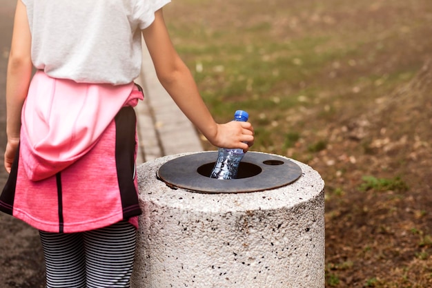 責任あるティーンエイジャーが都市公園のごみ箱にごみ、プラスチックごみを捨てる。