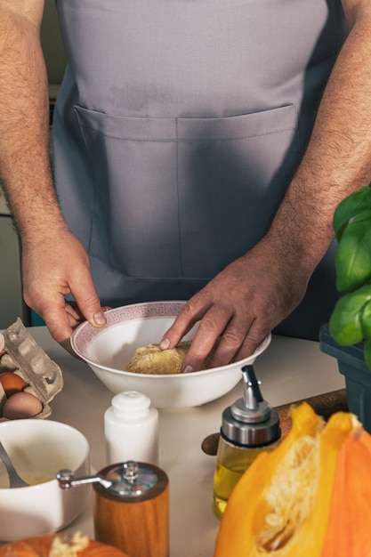 Thuis blijven en koken. Huisgemaakte Italiaanse ravioli van pompoenricotta. Mannen die deeg kneden.