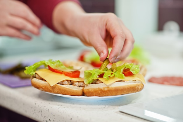 Thuis hamburgers bakken in de keuken tijdens quarantainetijd.