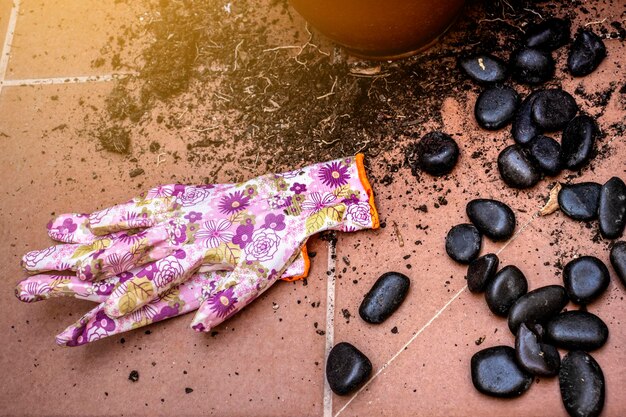 Thuis tuinieren Tuinhandschoenen voor vrouwen op de grond met aarde en stenen Sunlight