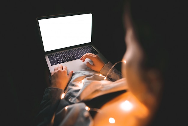 Thuis werken in een lampatmosfeer. vrouw en laptop met wit scherm, copyspace