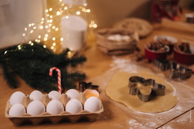 Thuisbakkerij die traditionele feestelijke snoepjes kookt die koekjes van ruw peperkoekdeeg op houten snijdt