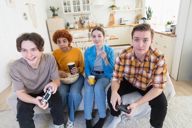 Thuisfeest vrolijke groep vrienden die thuis videogames spelen gelukkige diverse groep vrienden die