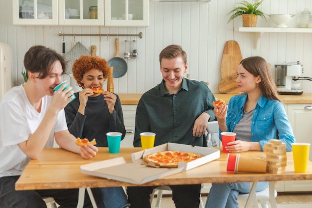 Thuisfeestje dolblij diverse vrienden eten bestelde pizza voor thuisfeestje gelukkige groep gemengd ras you