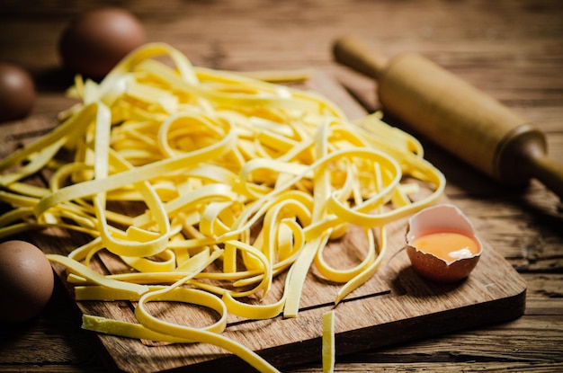 Thuisgemaakte pasta tagliatelle op een houten tafel