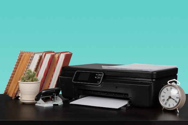 Thuislaserprinter op bureau tegen groene achtergrond