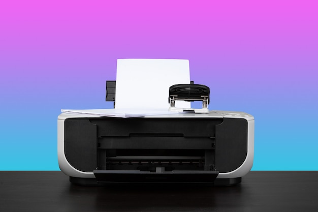 Foto thuislaserprinter op bureau tegen paarse achtergrond