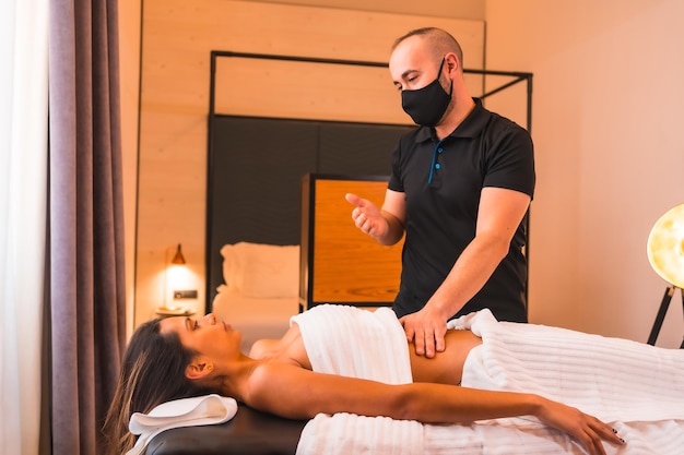 Thuismassage een jonge man die een massage uitvoert bij de klant thuis