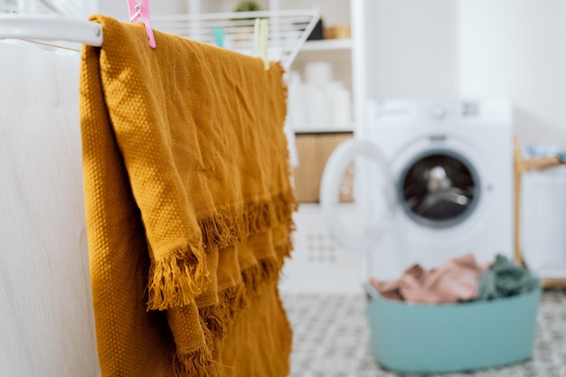 Thuiswas aan de droger hangt een gewassen deken die droogt vastgemaakt met clips