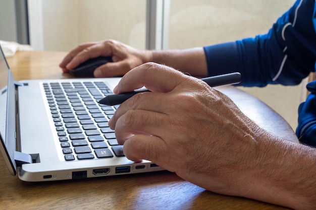 Thuiswerken man met computer en pen