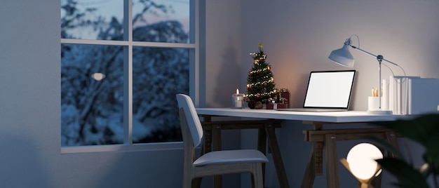 Thuiswerkruimte in de winternacht met laptopmodellicht van tafellampkerstboom