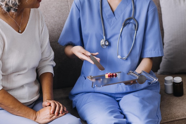 Thuiszorg verpleging en ouderen cardiologie gezondheidszorg Close-up van jonge Spaanse vrouwelijke arts verpleegkundige check volwassen blanke man patiënt hartslag met behulp van stethoscoop tijdens bezoek