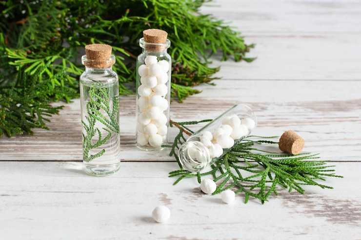 Photo thuja herbal pills and fresh branches of thuja homeopathy medicine concept
