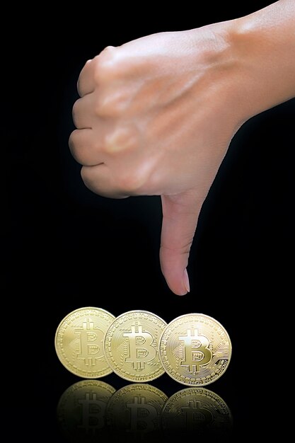 Foto pollice verso il basso segno della mano. bitcoin. bitcoin e nuovo concetto di denaro virtuale. bitcoin è una nuova valuta.