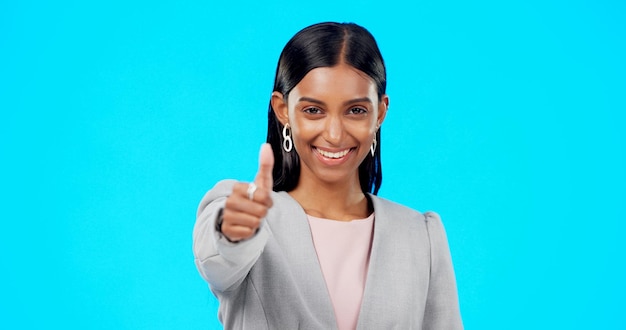 Thumbs up perfect and happy businesswoman doing accept hand gesture sign or symbol with smile excited agreement and portrait of female showing approval isolated in blue studio background