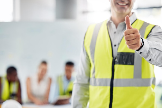 Thumbs up success and happy architect man standing against a blurred background Support welcome or thank you with industrial construction designer designing a building architecture project at work