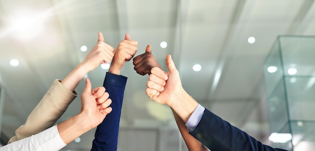 Thumbs up to success Shot of a group of hands showing thumbs up in an office