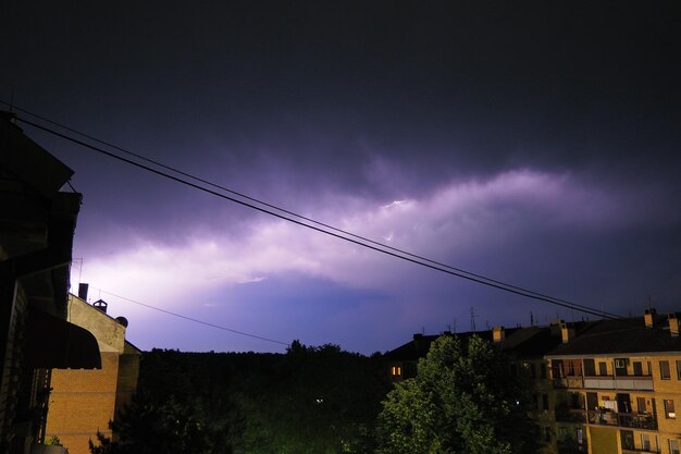 Temporale di notte sulla città lampi di fulmini e nuvole basse tuoni e fulmini cambiamento climatico dell'elemento naturale e concetto di previsioni del tempo scarica di elettricità nel cielo
