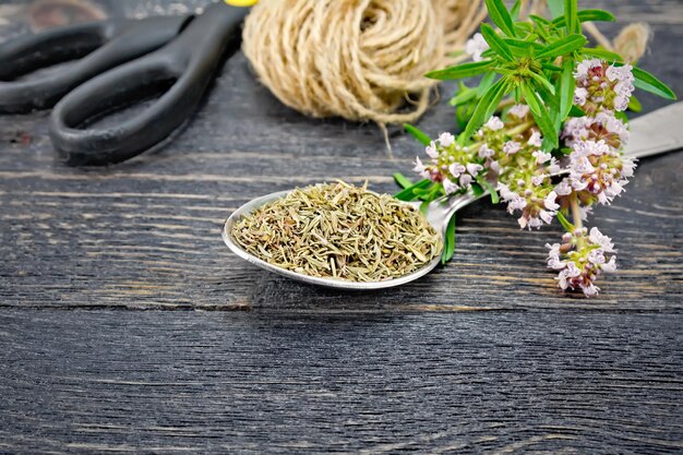 Photo thyme dry in spoon with twine on black board