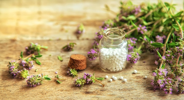 Thyme essential oil in a small bottle. Selective focus.