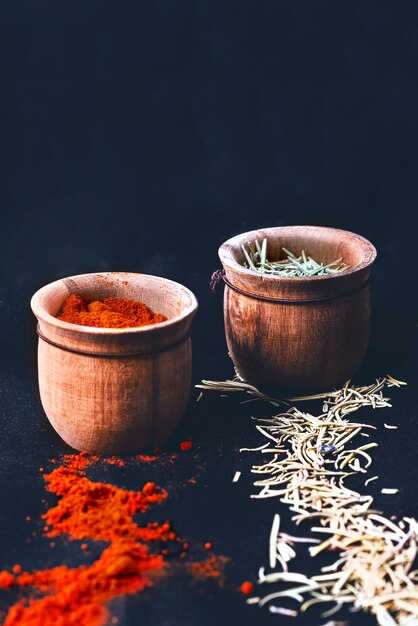 Thyme and paprika spices in wooden bowl