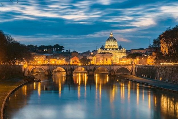 Tiber river by st peter basilica against sky at dusk