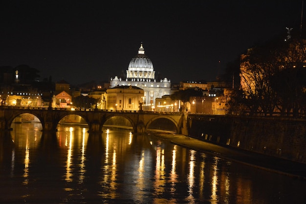 Foto il fiume tevere vicino alla basilica di san pietro di notte