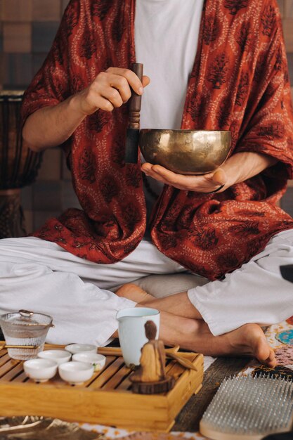 Tibetan singing bowl in the hands of a man during a tea ceremony