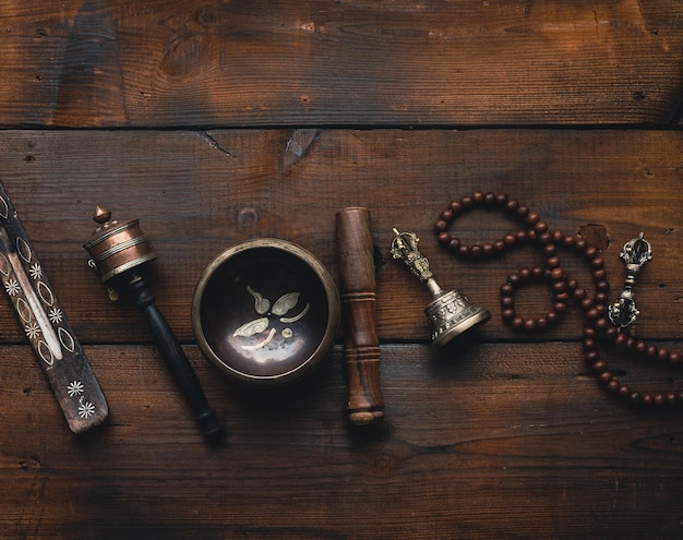 Tibetan singing copper bowl with a wooden clapper , objects for meditation and alternative medicine, top view. Plunging into a trance