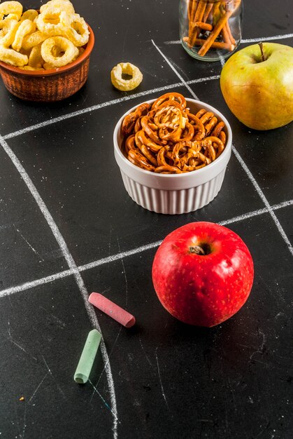 Tic tac toe healthy and unhealthy snack concept with crackers, chips and apples